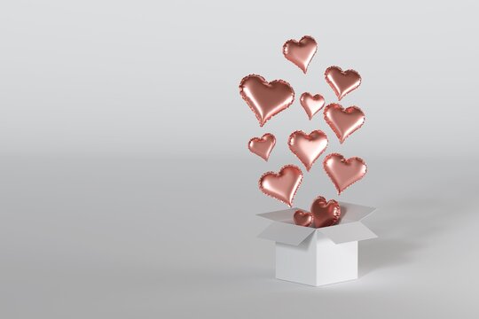 Red gold heart shaped balloons flying out of gift box, floating in the air over white studio background. Clean bright 3d illustartion with copy space for text.Surprise and love banner concept
