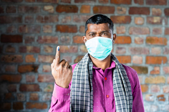 Construction Worker With Medical Face Mask Showing Ink Marked Finger After Voting In Election By Looking Camera - Concept Of Democracy And Indian Poll System