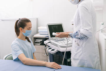 Doctor doing the ultrasound on the hand close up. Doctor demonstrates results of ultrasound to patient. Medical ultrasound scan. Rehabilitation application of Botox injection for muscle relaxation.