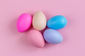 Colorful Easter eggs on a pink background, top view.