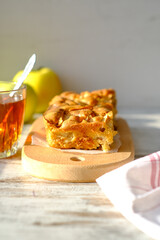 Culinary food template. Homemade Charlotte apple pie on a wooden plate with tea and apples in the background. Sweet organic vegan plant-based bakery.