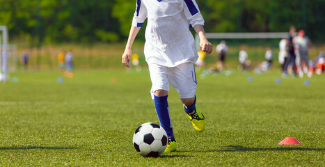 Sporty Kid Running With Soccer Ball on Grass Field. Sports Horizontal Background
