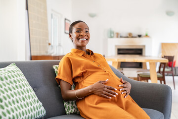 Happy mature african pregnant woman smiling at home