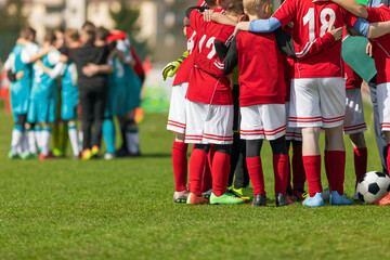 Obraz premium Two Football Teams Standing in Team Circles Before Tournament Final Match. School Soccer Players in Red and Blue Soccer Jersey Uniforms. Sports Kids on Briefing With Coach