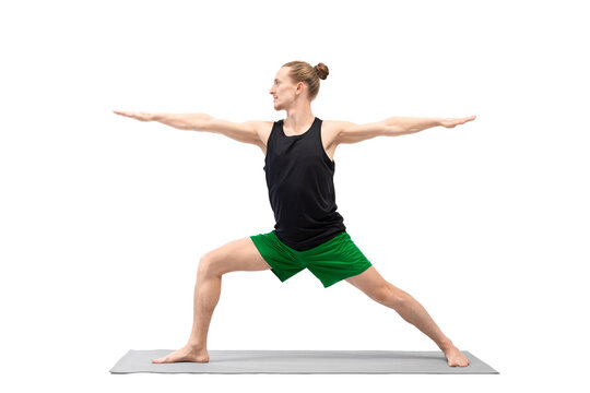 Male yoga, warrior II pose. Caucasian handsome man with bun hair practice Virabhadrasana, isolated on white.