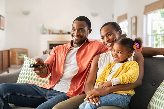 Happy african american family watching TV at home