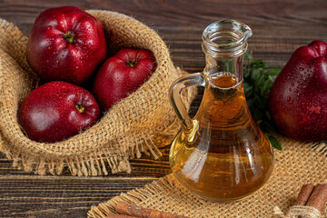 Apple cider vinegar and red apples on a dark, wooden background. Selective focus. fermented product. Healthy food.