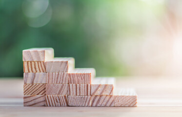 Hand arranging wood block stacking as step stair. Ladder career path concept for business growth success process.