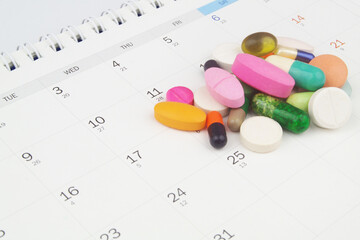 Many drugs and pills on calendar background.	