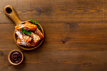 Churros with powdered sugar and chocolate sauce. Fast food sweets