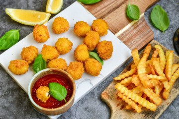 Fototapeta na wymiar Crispy deep fried chicken popcorn nuggets and french fries . Breaded with Cornflakes chicken Breast fillets with chilly peppers and fresh basil on wooden rustic background