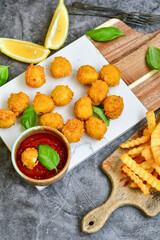 Crispy  deep fried   chicken  popcorn  nuggets . Breaded  with Cornflakes chicken  Breast fillets  with chilly peppers and fresh   basil on wooden rustic background