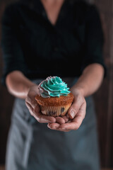 Delicious cupcake in the woman's hands.