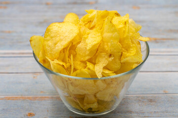 Potato chips or Crispy in a bowl on a wooden background. Close up