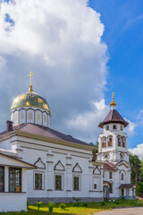 Fototapeta na wymiar Church to St. Grand Prince Alexander Nevsky in Pudozh after restoration. Orthodox temple and bell tower against blue sky in summer sunny day. Karelia, Russia