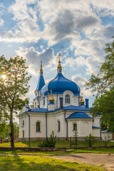 St. Nicholas church in Sortavala, Karelia, Russia. Old orthodox white stone temple with blue domes against cloudy sky at sunset. Beautiful summer landscape with architectural landmark