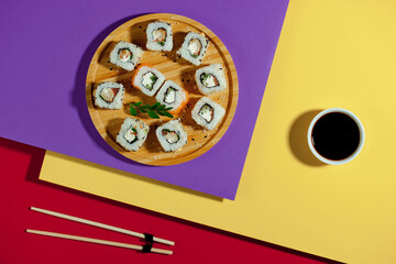 Sushi on a plate on a bright, colored background.