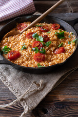 Risotto with tomatoes and parmesan cheese in a cast iron pan