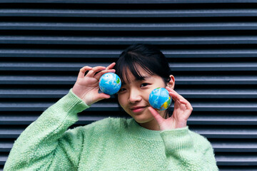 Woman with bangs holding small globes