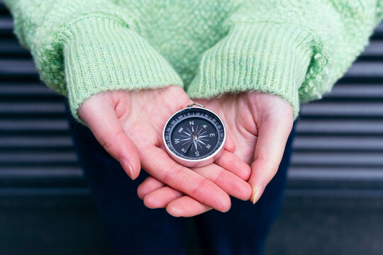 Woman holding navigational compass on palm