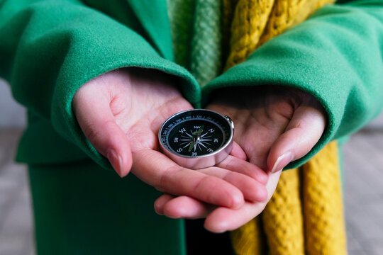 Hands of woman holding navigational compass