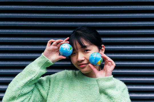 Woman with bangs holding small globes