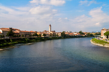 Obraz premium The river Adige in the Italian city of Verona. Waterfront with houses and a church tower.
