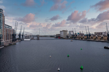 Port cranes with cityscape alongside river thames at royal Victoria dock in London