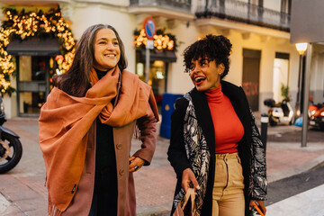 Diverse women with shopping bags walking on street