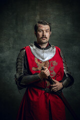 Vintage style portrait of brutal seriuos man, medieval warrior or knight with dirty wounded face...