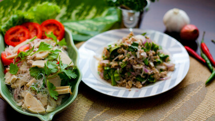 Spicy vietnamese sausages salad and Spicy minced pork.(Thai food) With onion, garlic, red pepper on a black wooden table
