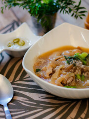 Wide Rice Noodles with pork in Gravy Sauce in white Plate or what we call 
