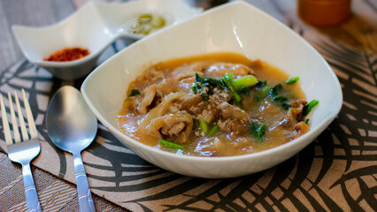 Wide Rice Noodles with pork in Gravy Sauce in white Plate or what we call 