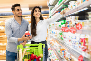 Arabic Couple On Grocery Shopping Buying Food In Modern Supermarket