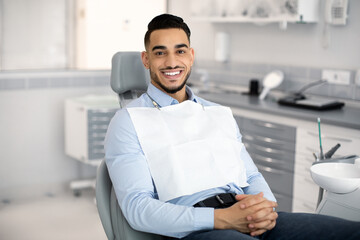 Stomatological Clinic. Portrait Of Handsome Arab Male Patient Sitting In Dentist Chair