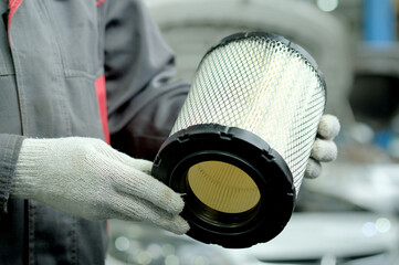 Spare parts for the car. The air filter is in the hands of an auto mechanic. Close-up. Car...