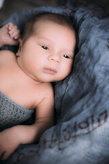 Soft picture of a beautiful baby boy 1-3 months laying on blue bedding in a basket wearing crochet blue crochet costume, newborn photography