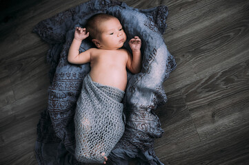 Soft picture of a beautiful baby boy 1-3 months laying on blue bedding in a basket wearing crochet blue crochet costume, newborn photography