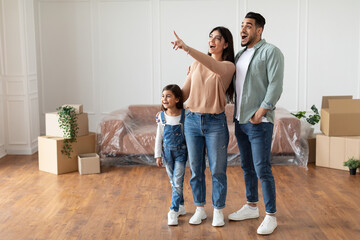 Happy muslim family buying new apartment, pointing finger - obrazy, fototapety, plakaty