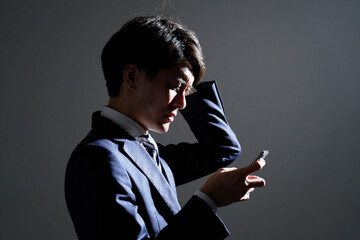 ビジネスマン　スマホ　悩む　シルエット