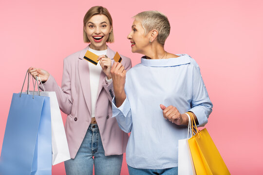 Happy Young Woman And Mature Mother Holding Shopping Bags And Credit Cards Isolated On Pink