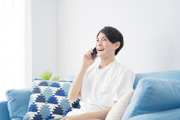 男性　電話する　リビング