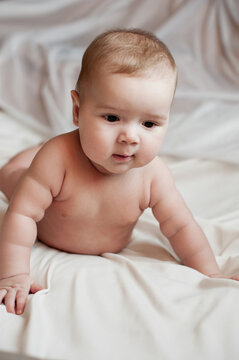 Soft picture of a beautiful baby boy 1-3 months laying on white bedding newborn photography