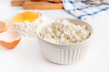 A collection of tools and ingredients for homemade baking with cottage cheese in the foreground. Cooking at home, an appetizing composition of products for cooking