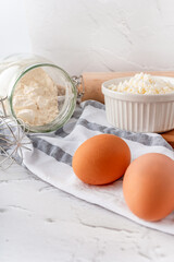 A beautiful composition of baking ingredients with eggs in the foreground.