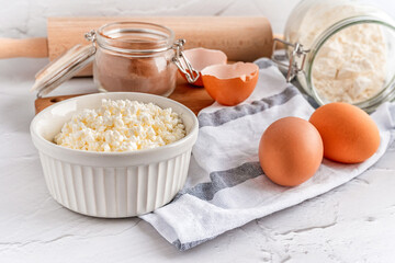 A collection of tools and ingredients for homemade baking with cottage cheese in the foreground. Cooking at home, an appetizing composition of products for cooking