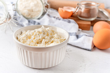A collection of tools and ingredients for homemade baking with cottage cheese in the foreground. Cooking at home, an appetizing composition of products for cooking