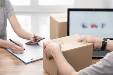 Parcel officer man close Parcel box from women and use laptop to register in the online system to send parcels and women write the document delivery address in the form of the parcel delivery