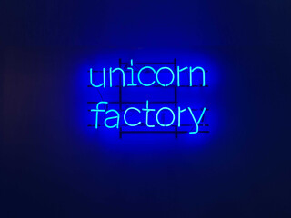 Unicorn factory neon sign on the blue background