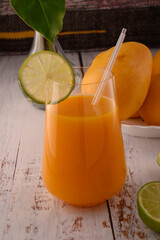 Mango beverage close up with lime slice on white vintage wooden table © ALEKSEI